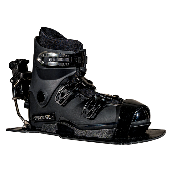 Angled front view of the Syndicate Hardshell boot, showing black construction, adjustable straps, and a metal heel release.