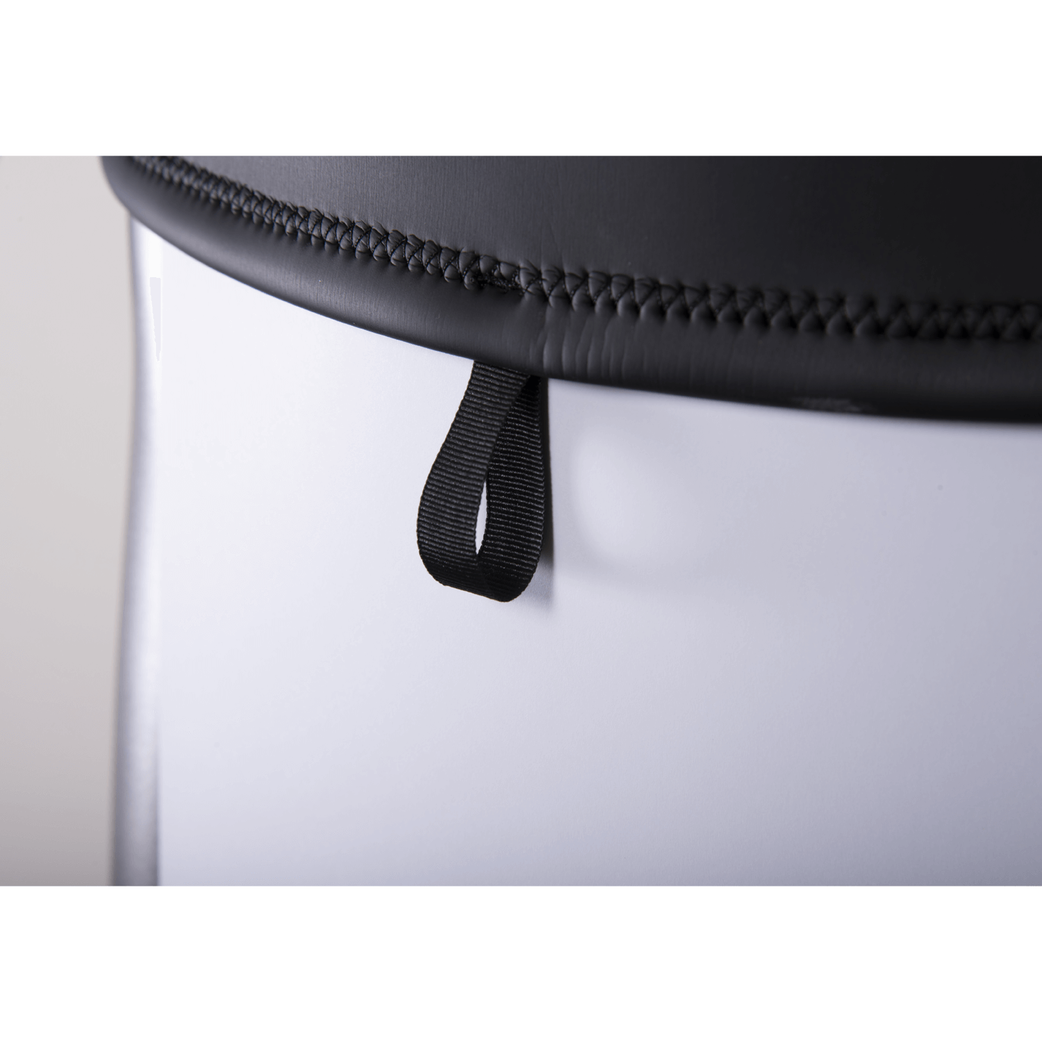 Close-up of the wetsuit hem, featuring a black stitched edge with a small pull loop for easy adjustments.